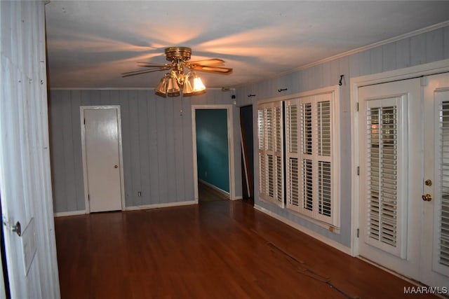 unfurnished room with dark wood-type flooring, ornamental molding, and ceiling fan