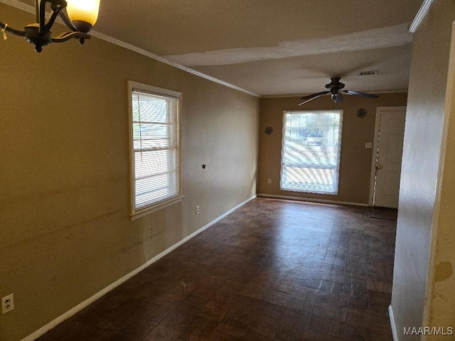 spare room featuring ceiling fan with notable chandelier and ornamental molding