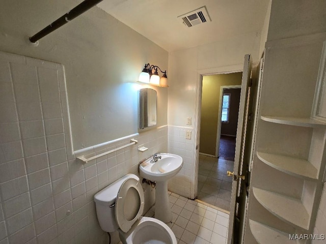 bathroom featuring sink, tile walls, tile patterned floors, and toilet