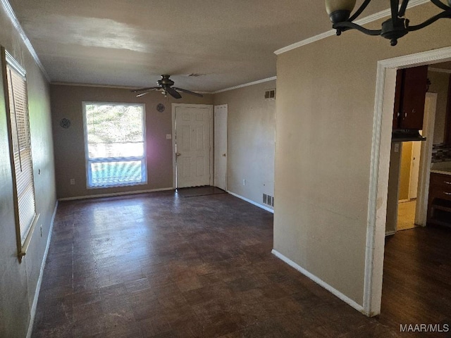 spare room with a ceiling fan, visible vents, ornamental molding, and baseboards