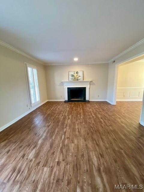 unfurnished living room with wood-type flooring and crown molding