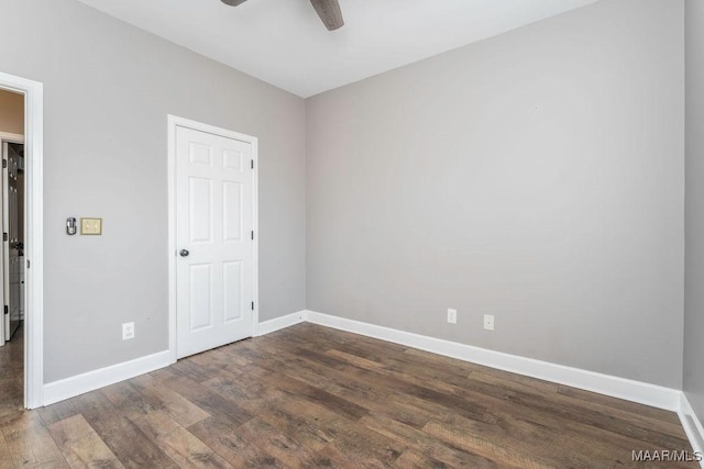 spare room with dark wood-type flooring and ceiling fan