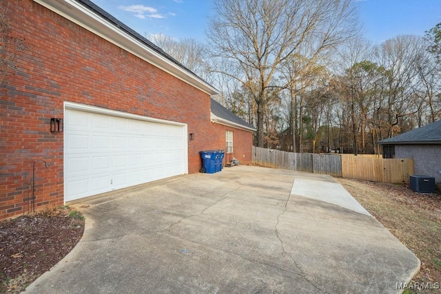 view of side of home with cooling unit and a garage