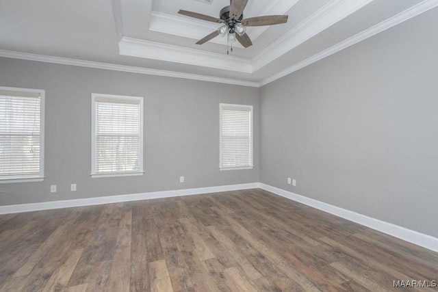 unfurnished room with dark wood-type flooring, ceiling fan, crown molding, and a raised ceiling