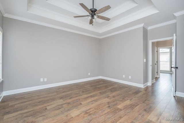 spare room with a tray ceiling, ornamental molding, ceiling fan, and hardwood / wood-style flooring