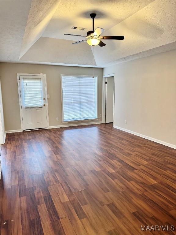 unfurnished room featuring dark wood-type flooring and a textured ceiling