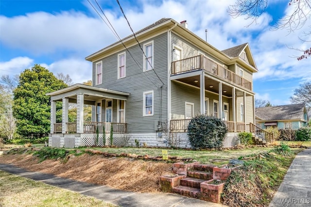 view of side of property featuring a balcony and a porch