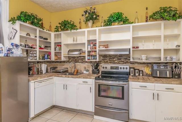 kitchen featuring stainless steel appliances, sink, white cabinets, and decorative backsplash