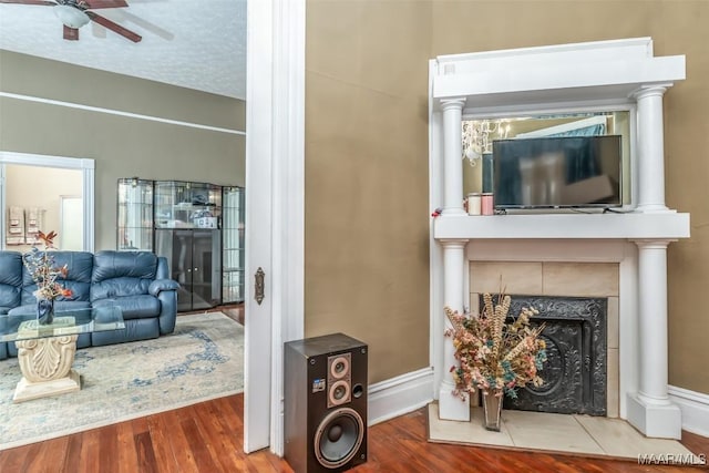 living room with hardwood / wood-style floors, a textured ceiling, and ceiling fan