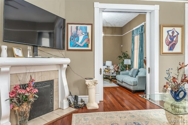 room details with a tiled fireplace and hardwood / wood-style floors