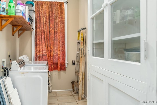 clothes washing area with washer and dryer and light tile patterned floors