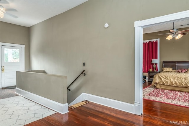 stairway featuring ceiling fan and wood-type flooring