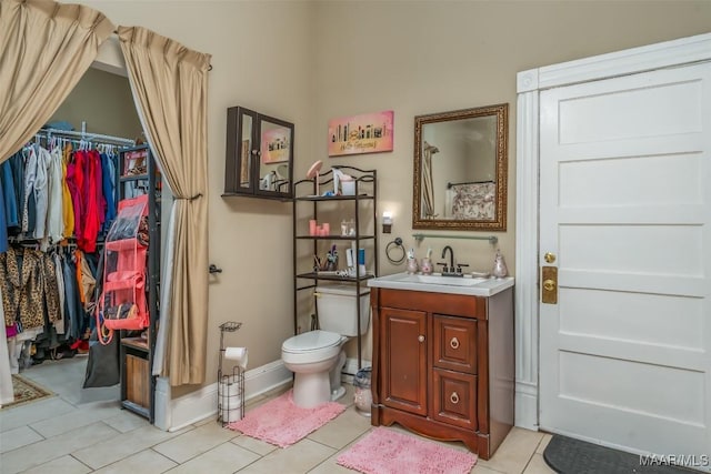 bathroom featuring tile patterned flooring, vanity, and toilet