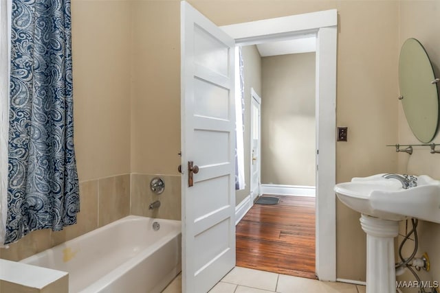 bathroom featuring a tub, sink, and tile patterned floors