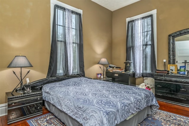 bedroom with dark hardwood / wood-style floors