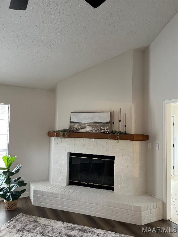 details featuring hardwood / wood-style flooring, a brick fireplace, and a textured ceiling