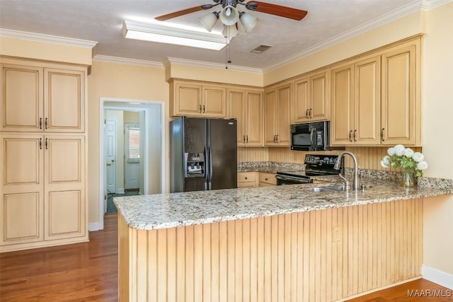 kitchen with light stone counters, hardwood / wood-style flooring, kitchen peninsula, and black appliances