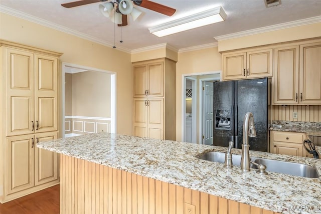 kitchen featuring sink, black fridge, crown molding, light stone counters, and hardwood / wood-style floors