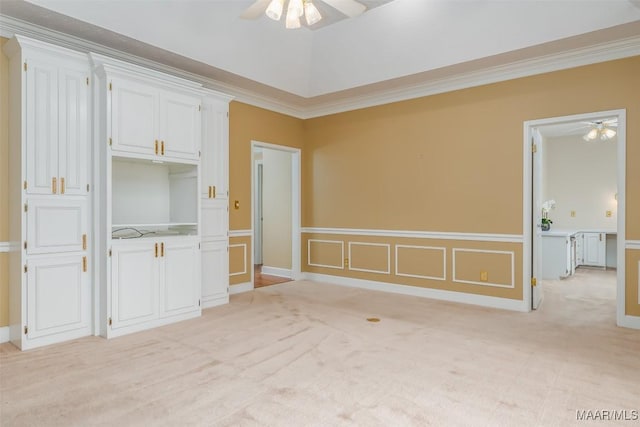 carpeted empty room featuring crown molding, lofted ceiling, and ceiling fan