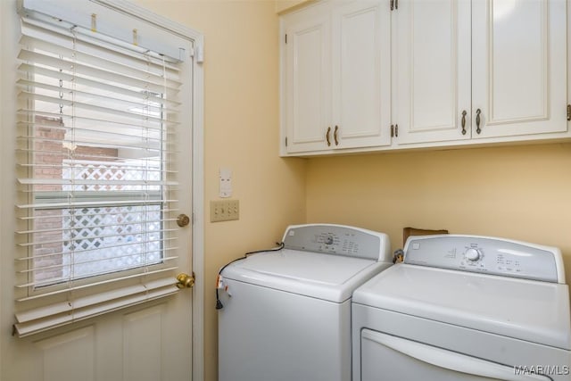 clothes washing area with cabinets and independent washer and dryer