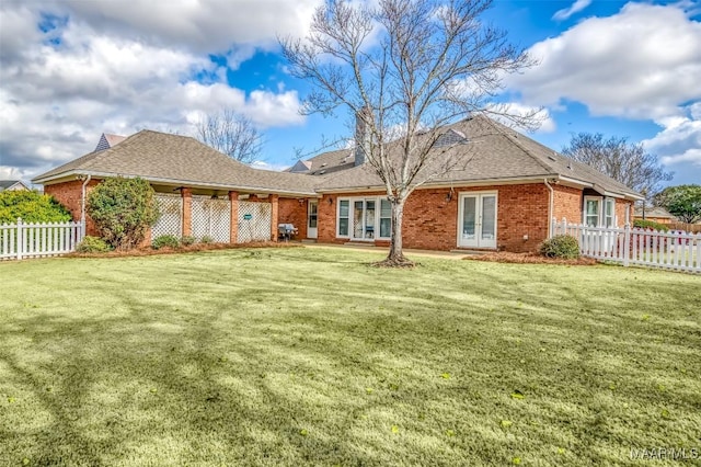 rear view of property featuring a lawn and french doors