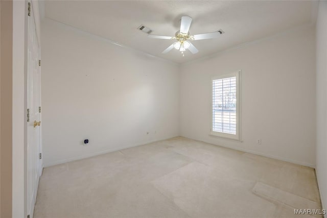 spare room with crown molding, light colored carpet, and ceiling fan