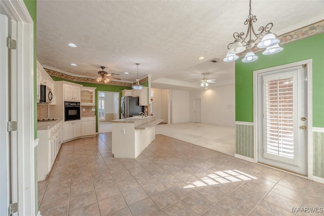 kitchen featuring white cabinetry, pendant lighting, ceiling fan, and black appliances