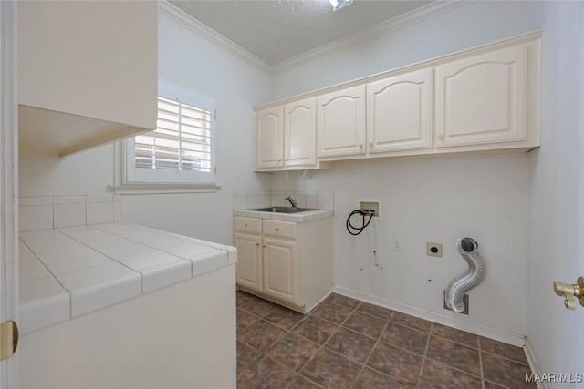 washroom with sink, crown molding, cabinets, hookup for a washing machine, and hookup for an electric dryer