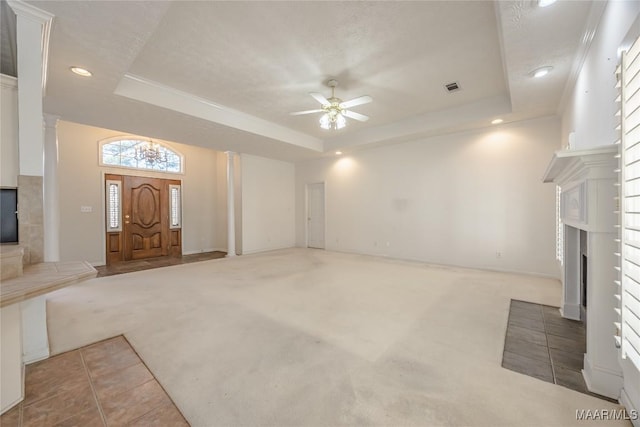 unfurnished living room featuring ceiling fan, light colored carpet, a tray ceiling, and a textured ceiling