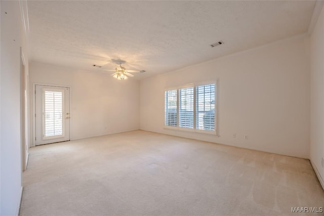 carpeted empty room with ceiling fan and a textured ceiling