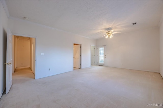 carpeted spare room with ceiling fan, ornamental molding, and a textured ceiling