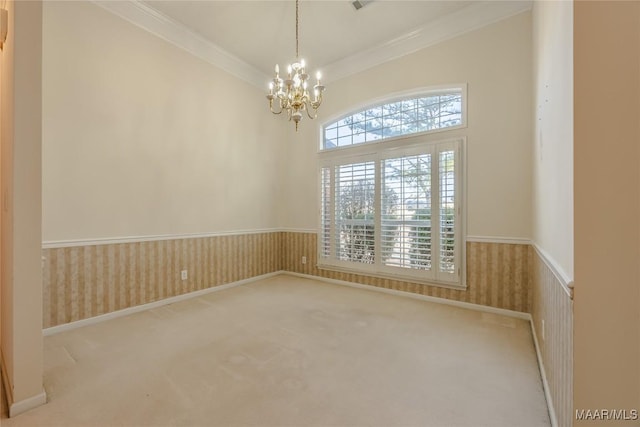 carpeted spare room with an inviting chandelier and crown molding