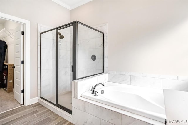 bathroom featuring ornamental molding, separate shower and tub, and hardwood / wood-style floors