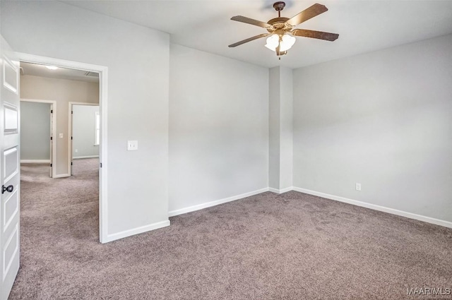 carpeted spare room featuring ceiling fan