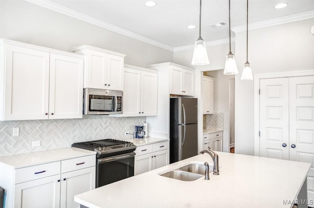 kitchen featuring white cabinetry, decorative light fixtures, an island with sink, and appliances with stainless steel finishes