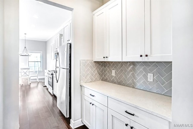 kitchen featuring pendant lighting, appliances with stainless steel finishes, white cabinetry, backsplash, and light stone counters