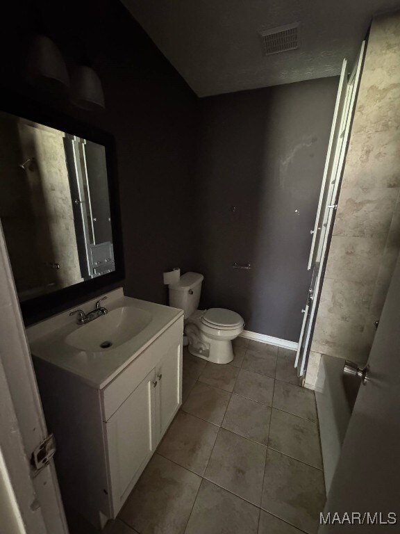 2716 Baldwin Brook Dr, Montgomery, AL 36116 - full bathroom with tile patterned flooring, toilet, vanity, a tub to relax in, and baseboards