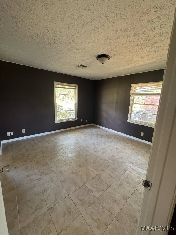 2716 Baldwin Brook Dr, Montgomery, AL 36116 - tiled empty room with a textured ceiling and baseboards