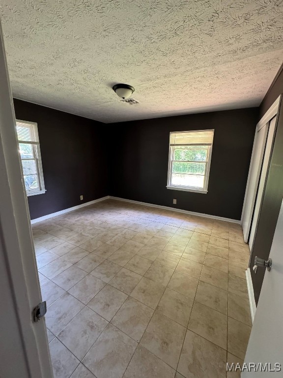 2716 Baldwin Brook Dr, Montgomery, AL 36116 - unfurnished room featuring a textured ceiling, baseboards, and light tile patterned floors