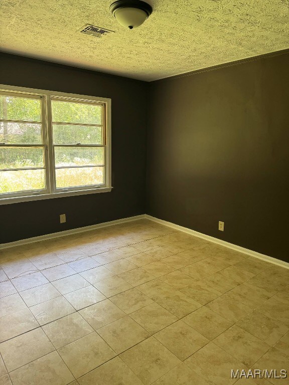 2716 Baldwin Brook Dr, Montgomery, AL 36116 - tiled empty room with baseboards and a textured ceiling