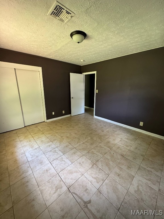2716 Baldwin Brook Dr, Montgomery, AL 36116 - unfurnished bedroom with a textured ceiling, light tile patterned floors, and baseboards
