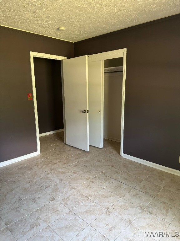 2716 Baldwin Brook Dr, Montgomery, AL 36116 - unfurnished bedroom with a textured ceiling, a closet, and baseboards
