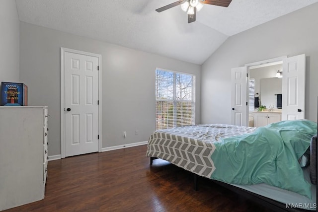 bedroom with lofted ceiling, dark hardwood / wood-style flooring, connected bathroom, and a textured ceiling