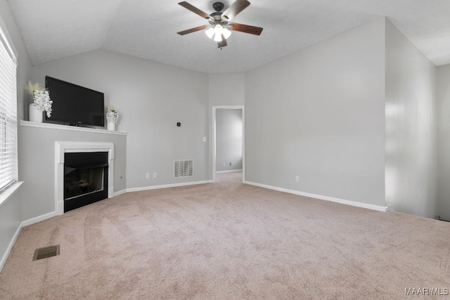 unfurnished living room featuring vaulted ceiling, ceiling fan, and carpet