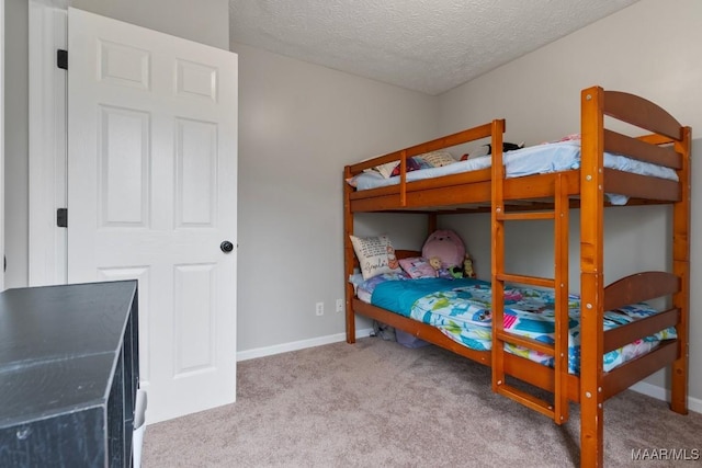 bedroom featuring light carpet and a textured ceiling