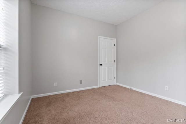 empty room with a textured ceiling and carpet