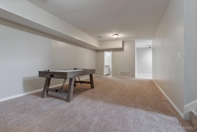 playroom featuring carpet flooring and a textured ceiling