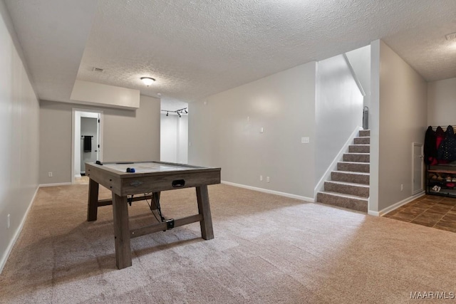 recreation room with carpet flooring and a textured ceiling