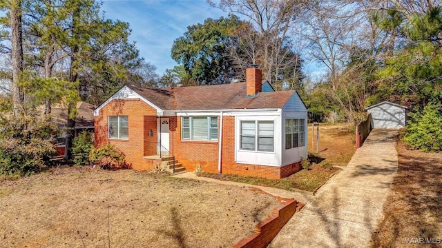 bungalow-style home with a garage and an outbuilding