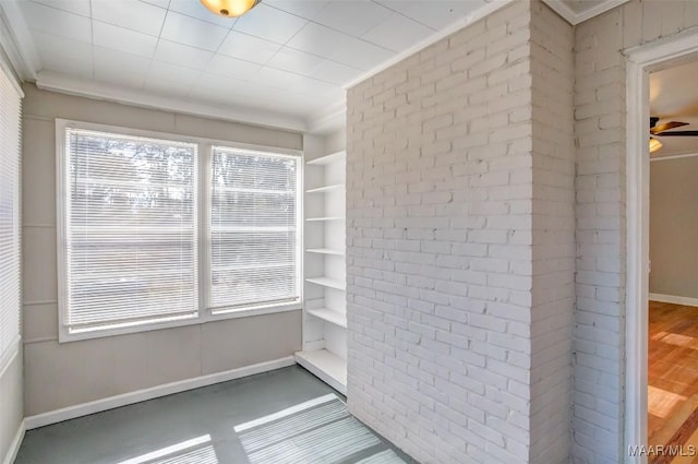 unfurnished sunroom with ceiling fan